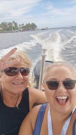 Two friends enjoy a fun day on the water, capturing a joyful moment while boating. Perfect for showcasing group adventures and celebrations on the water.