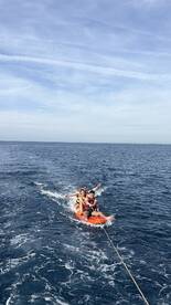 A group enjoys tubing on the open water, showcasing the thrill of water activities and fun under the sun.
