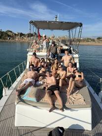 A lively group enjoys a sunny day on the deck of a boat, perfect for celebrations and social gatherings on the water.