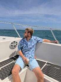 A man enjoys a refreshing cocktail while relaxing on the deck of a boat, capturing the essence of a perfect day on the water.