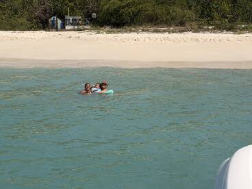 A joyful family enjoys a refreshing swim in the turquoise waters, creating lasting memories at the beach.
